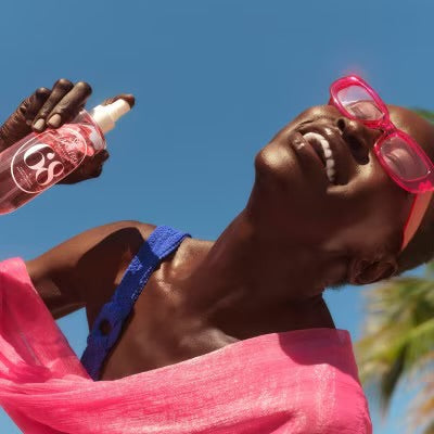 Model enjoying Sol de Janeiro Brazilian Crush Cheirosa 68 Perfume Mist on the beach