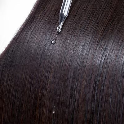 Color Wow Dream Coat serum being applied to dark hair