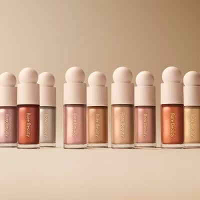 Rare Beauty Positive Light Liquid Luminizer shade swatches on three skin tones