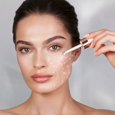 Model applying Charlotte's Magic Serum Crystal Elixir to face